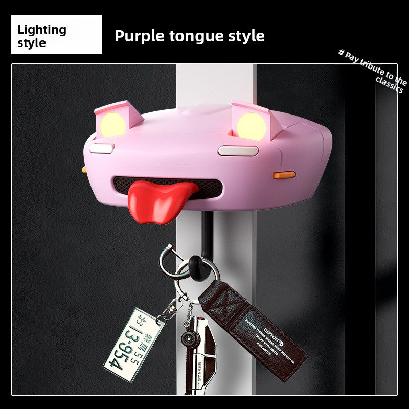 Pink car-shaped key holder with a red tongue on a black background
