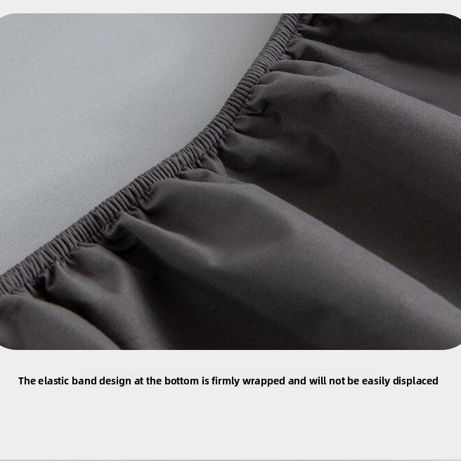 Dark gray fitted sheet with elastic band at the bottom on a light gray surface.