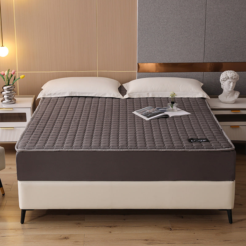 Gray mattress topper on a bed in a bedroom setting