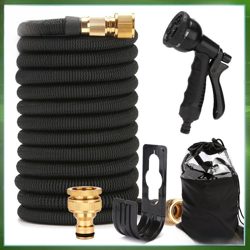 Black expandable garden hose set with brass connectors and black spray nozzle on a white background.