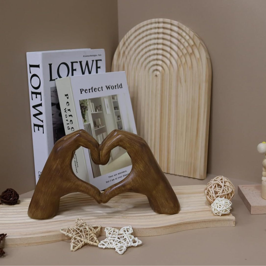 Wooden heart-shaped object on a shelf with books and decorative items.