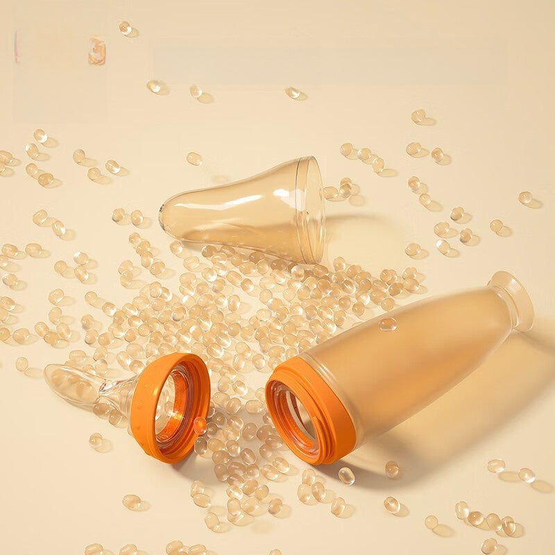 Two glass bottles with orange lids on a beige background with small glass beads.