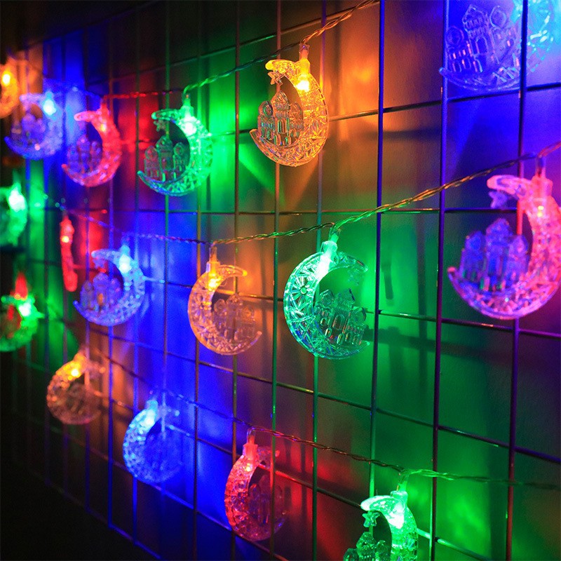 Colorful string lights shaped like moons on a tiled wall.