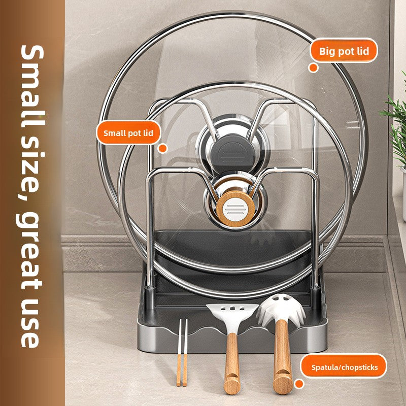 Kitchen utensil holder with pots, lids, spatula, and chopsticks on a neutral background