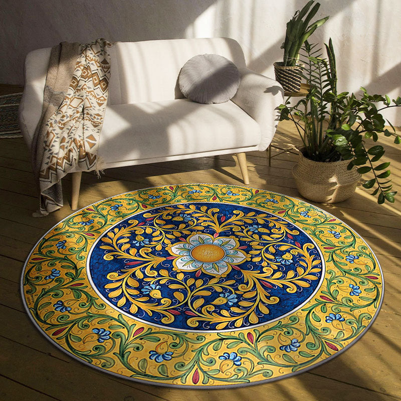 Decorative round rug with floral pattern in a room with a white sofa and plants.