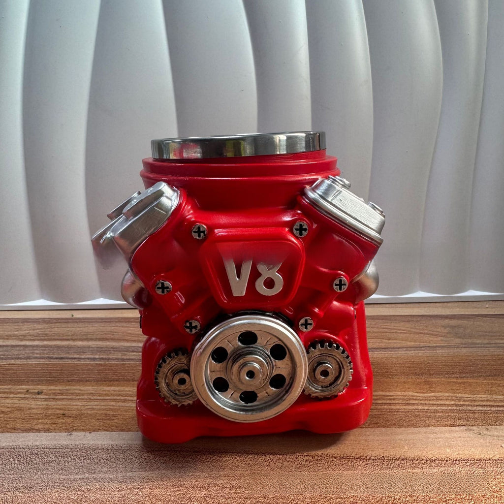 Red V8 engine model on a wooden surface with white curtain background