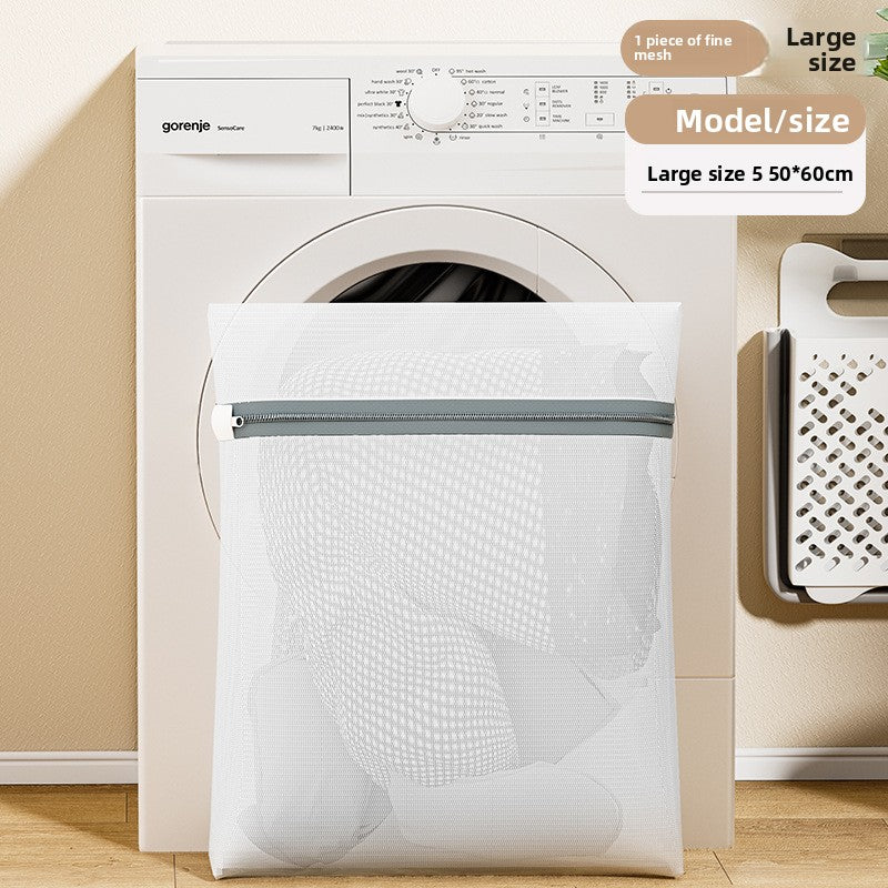 White mesh laundry bag with a zipper in front of a washing machine.