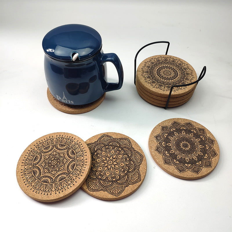 Set of cork coasters with mandala designs and a blue mug on a white background