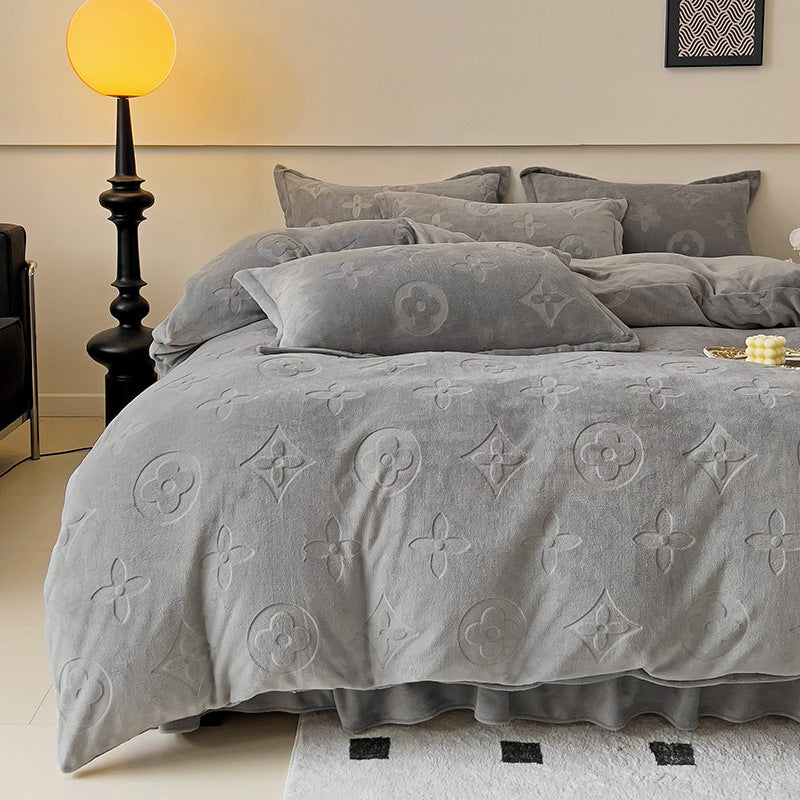 Gray textured comforter with floral patterns on a bed in a bedroom setting.