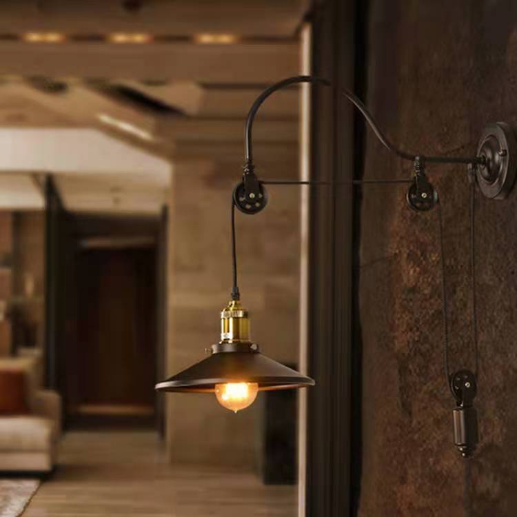 Wall-mounted industrial-style lamp with a blurred indoor setting
