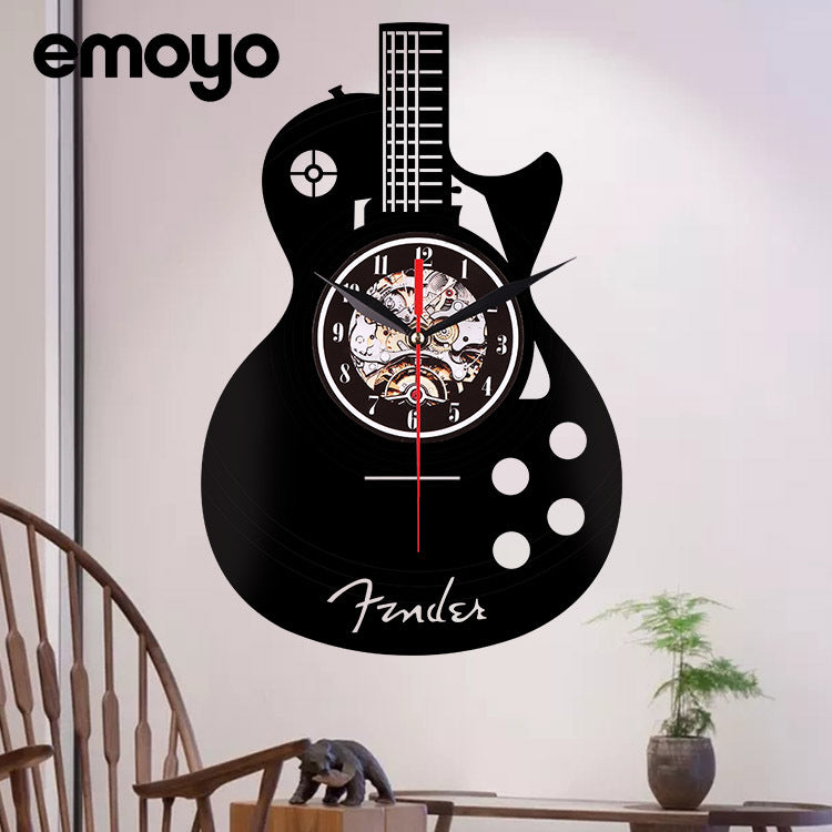 Guitar-shaped wall clock with 'Fender' branding on a white wall.
