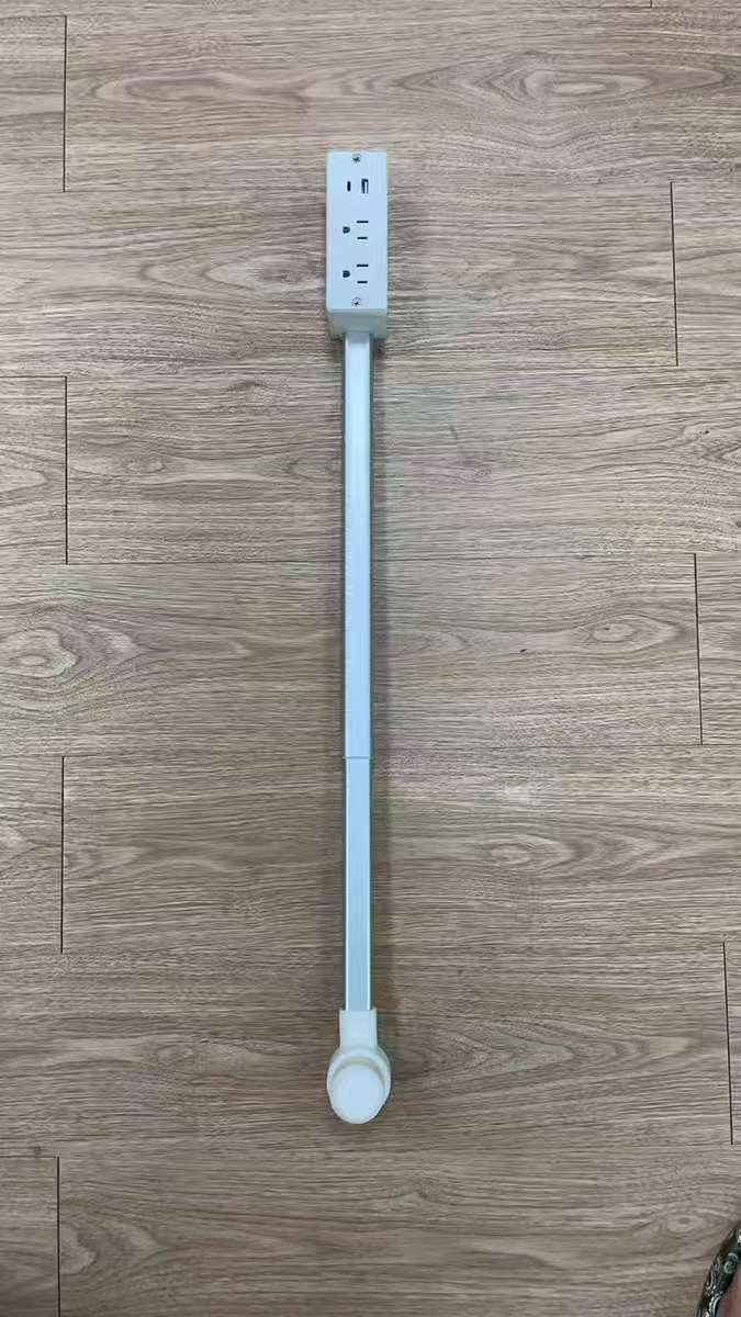 Long white plastic strip with a switch on a wooden floor