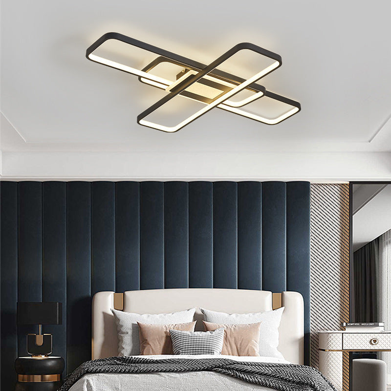 Modern ceiling light fixture in a bedroom setting with a bed and decorative pillows.