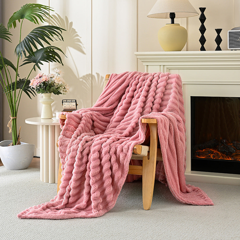 Pink blanket draped over a wooden chair in a cozy living room with a fireplace.