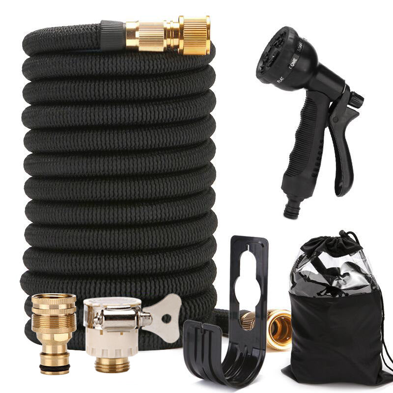 Black expandable garden hose with brass connectors and a black spray nozzle on a white background.