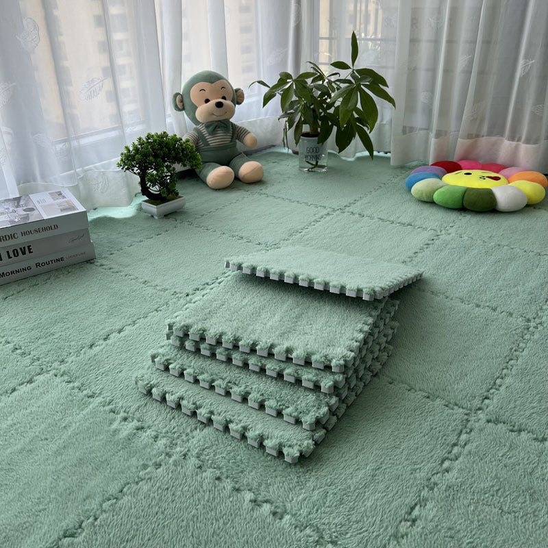 Stack of green interlocking foam mats on a light green floor with toys and plants in the background.