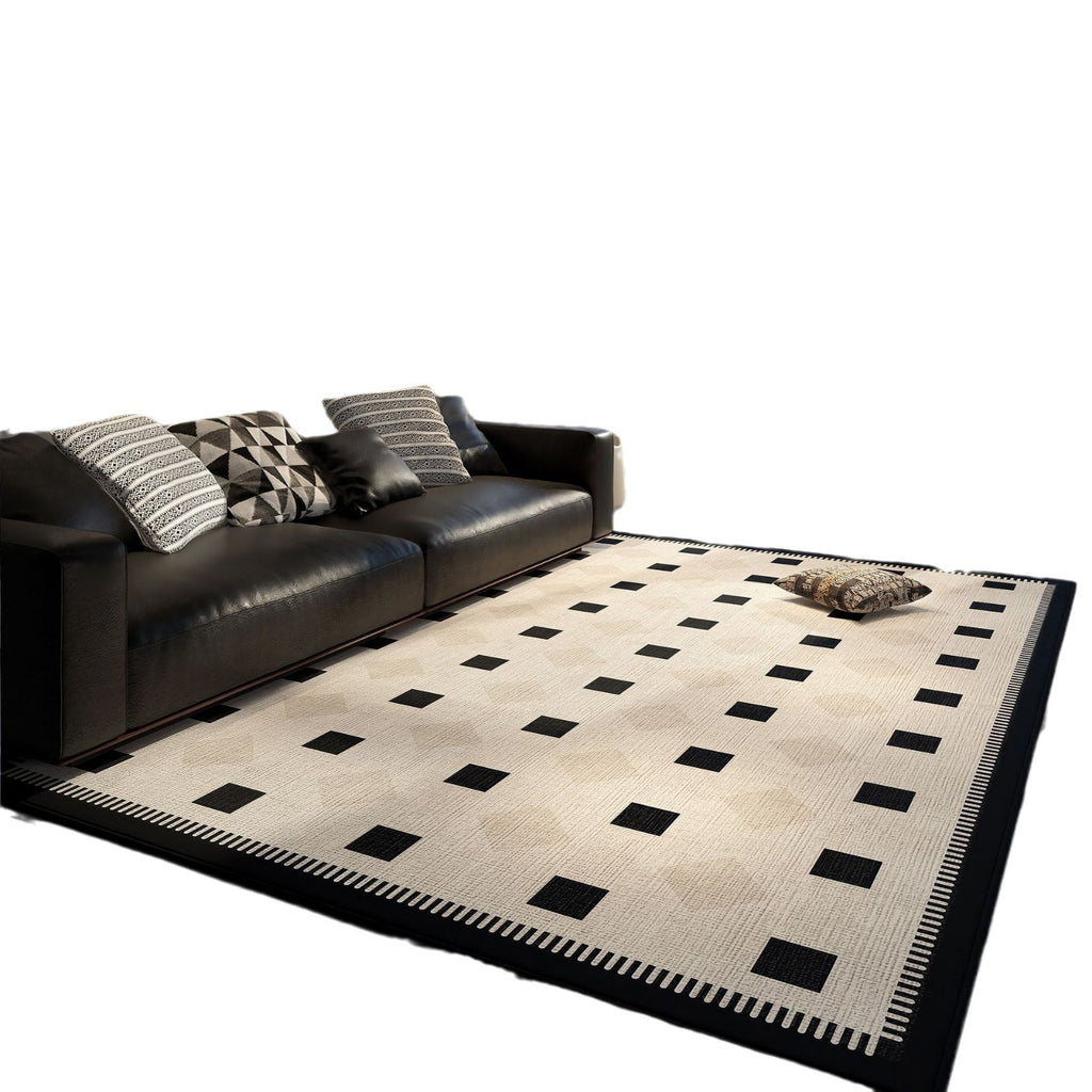 Beige and black checkered rug in front of a black leather sofa with patterned cushions.