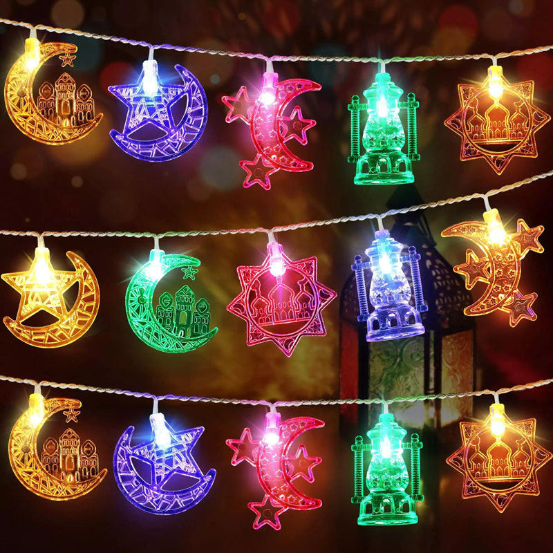 Decorative string lights with moon, star, and mosque designs on a dark background.