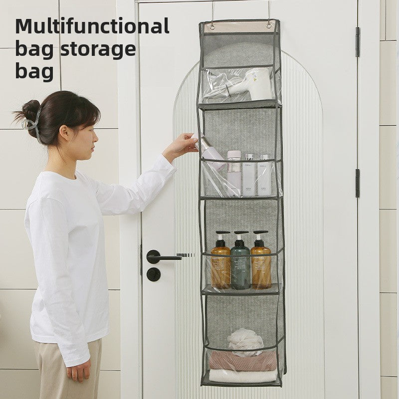 Woman using a multifunctional bag storage bag hanging on a door with various items inside.