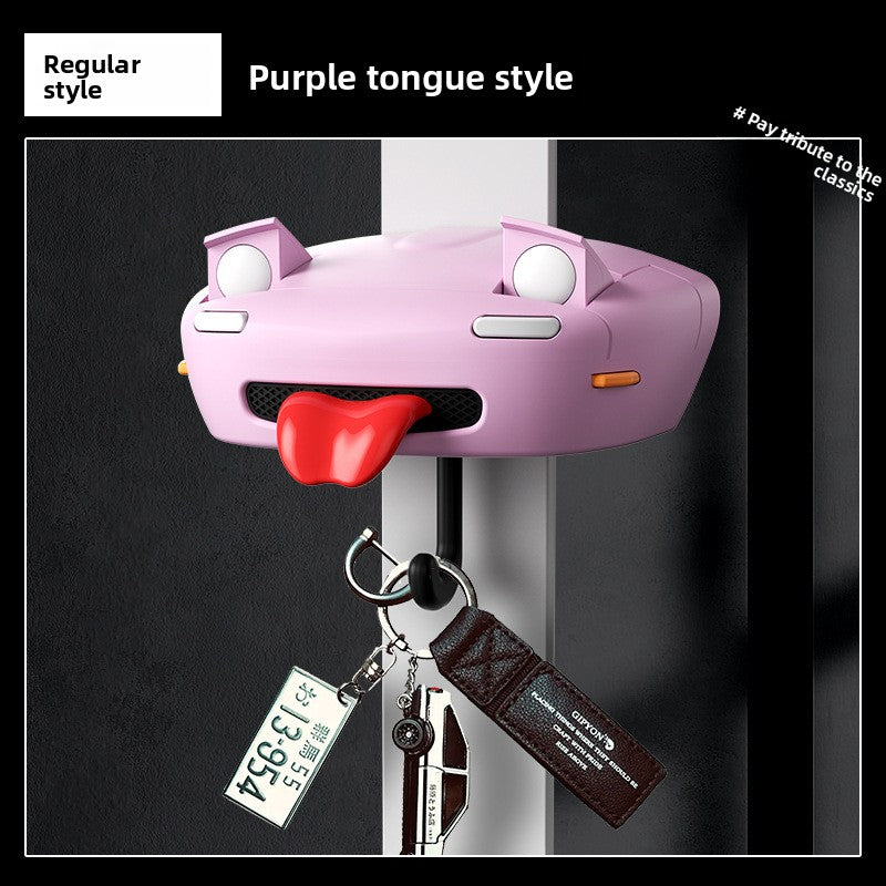 Purple car-shaped key holder with a red tongue hanging on a door handle.