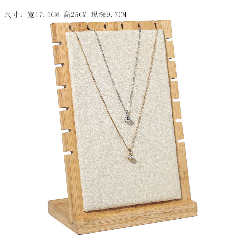 Two necklaces on a wooden stand with a white background