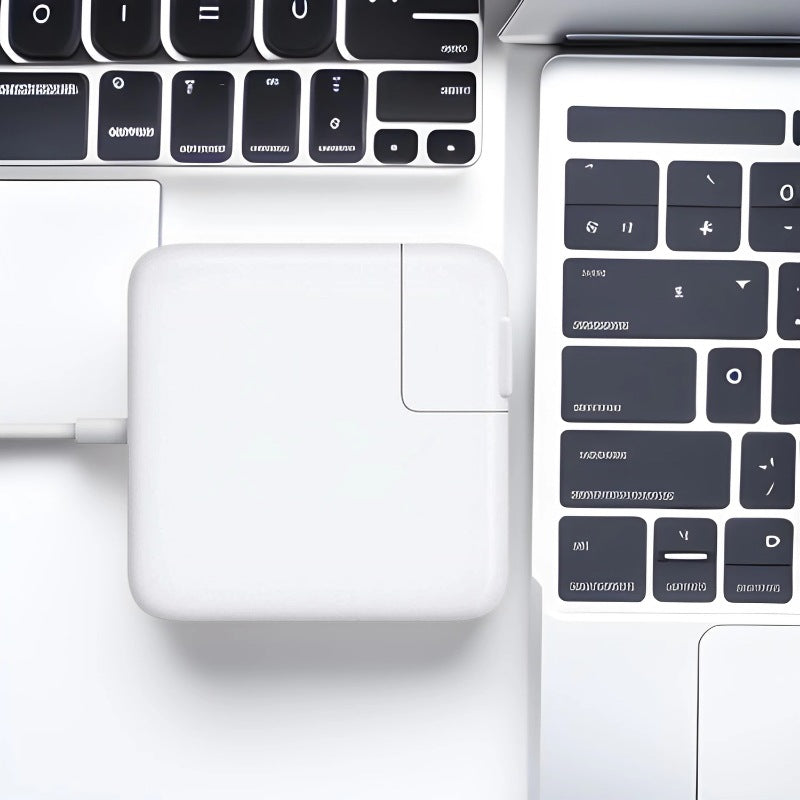 Close-up of a laptop with a power adapter on a white background