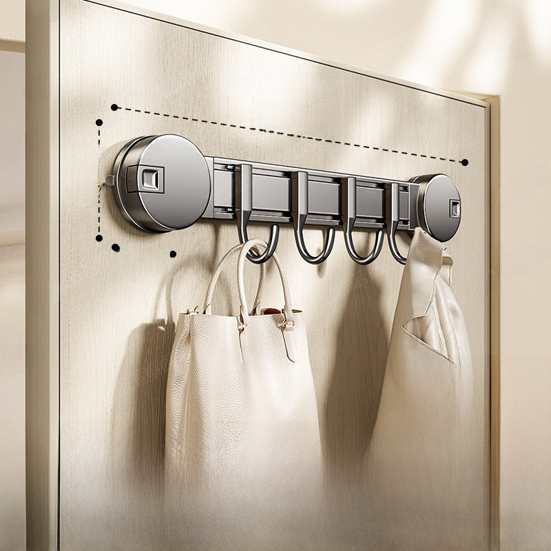 Wall-mounted hook with multiple hooks holding bags on a metallic surface