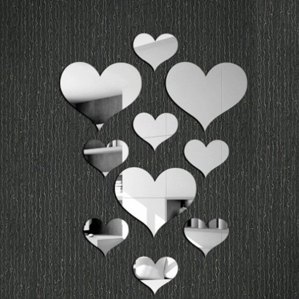 Heart-shaped mirror stickers on a textured black wall
