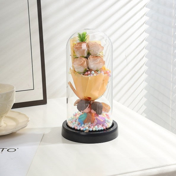 Decorative item with flowers and a clock inside a glass dome on a white surface.