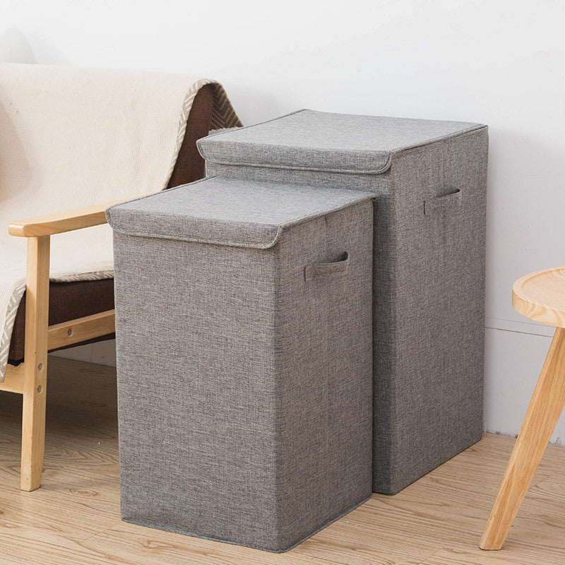 Gray fabric storage ottoman with lid in a room setting.