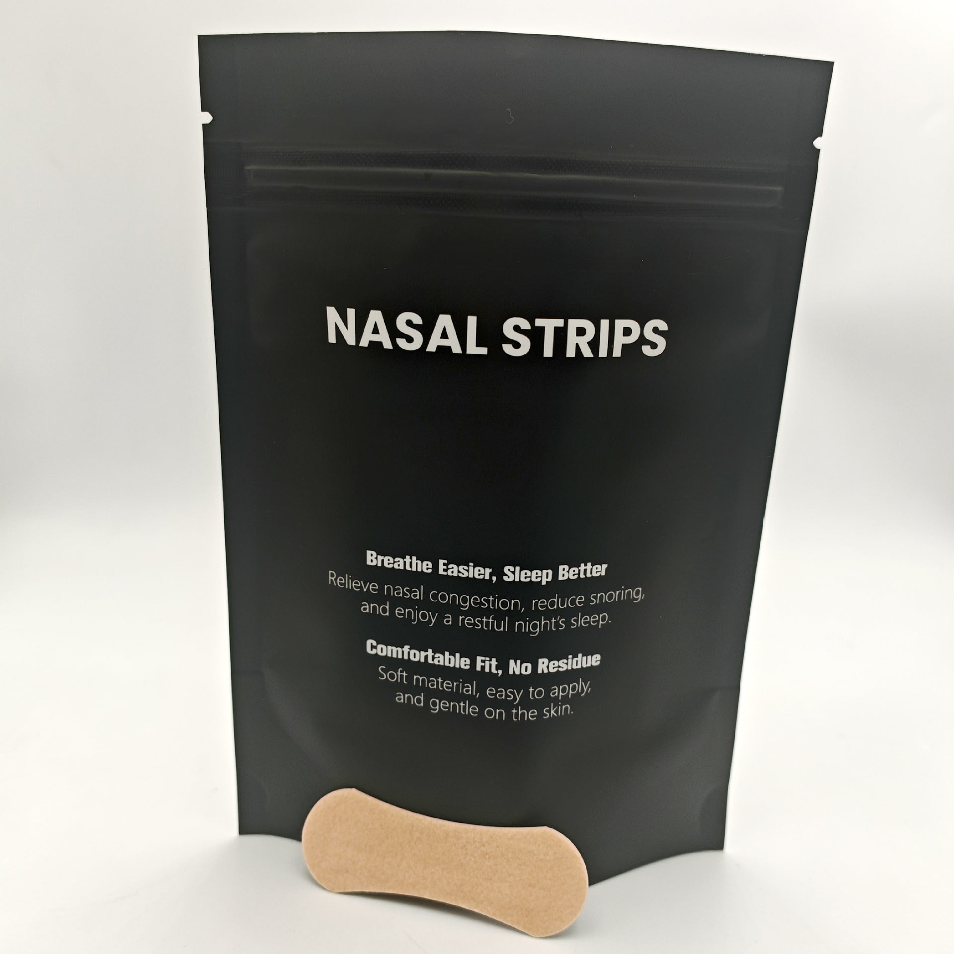 Black package of nasal strips with a wooden strip in front on a white background