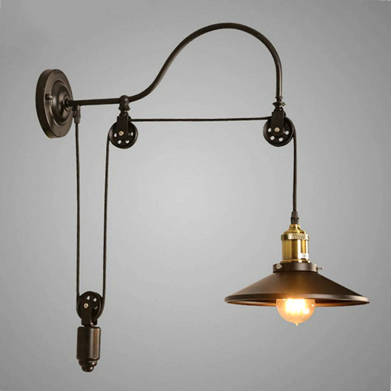 Wall-mounted industrial-style lamp with pulley system on a gray background