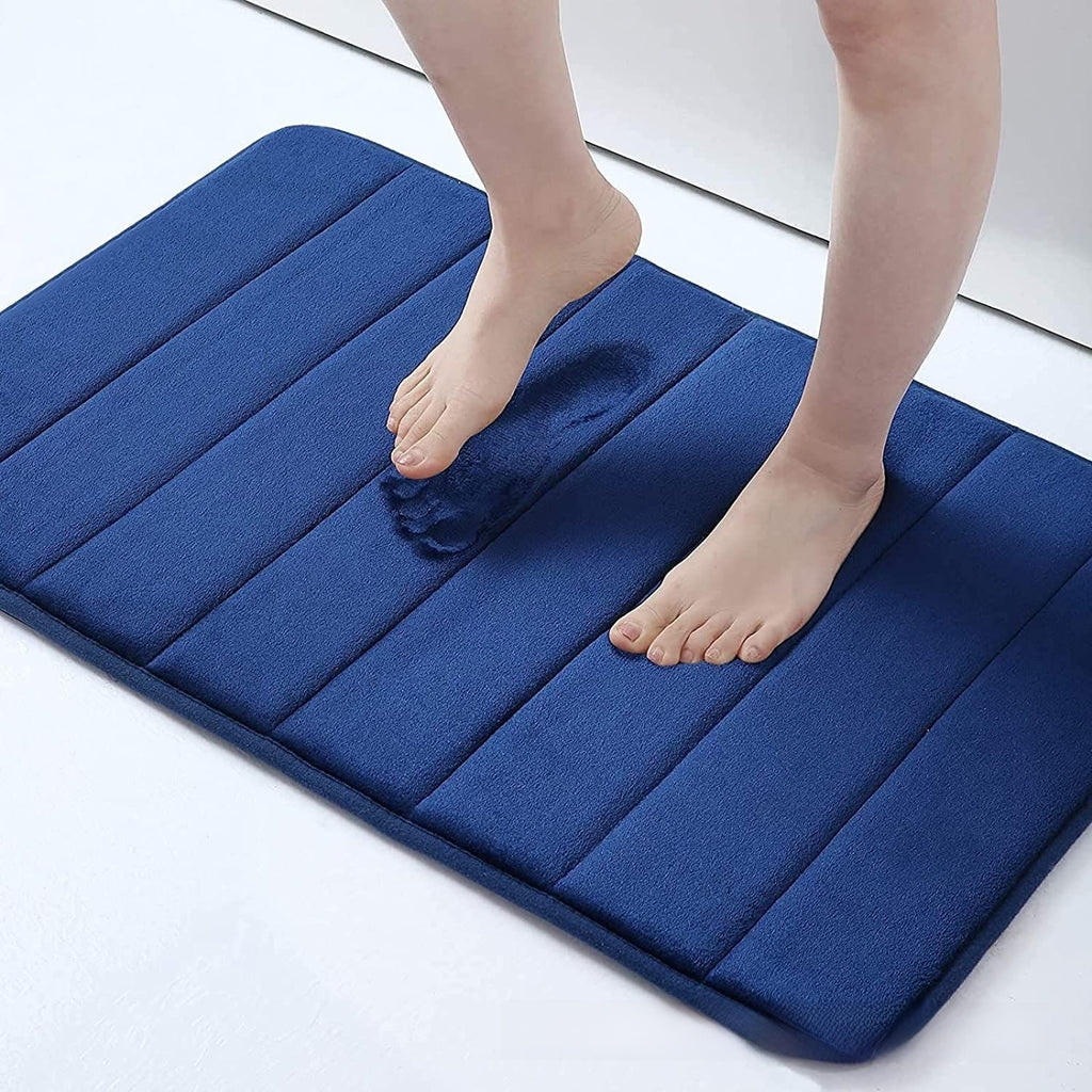 Blue cushioned mat with a person stepping onto it on a white floor.