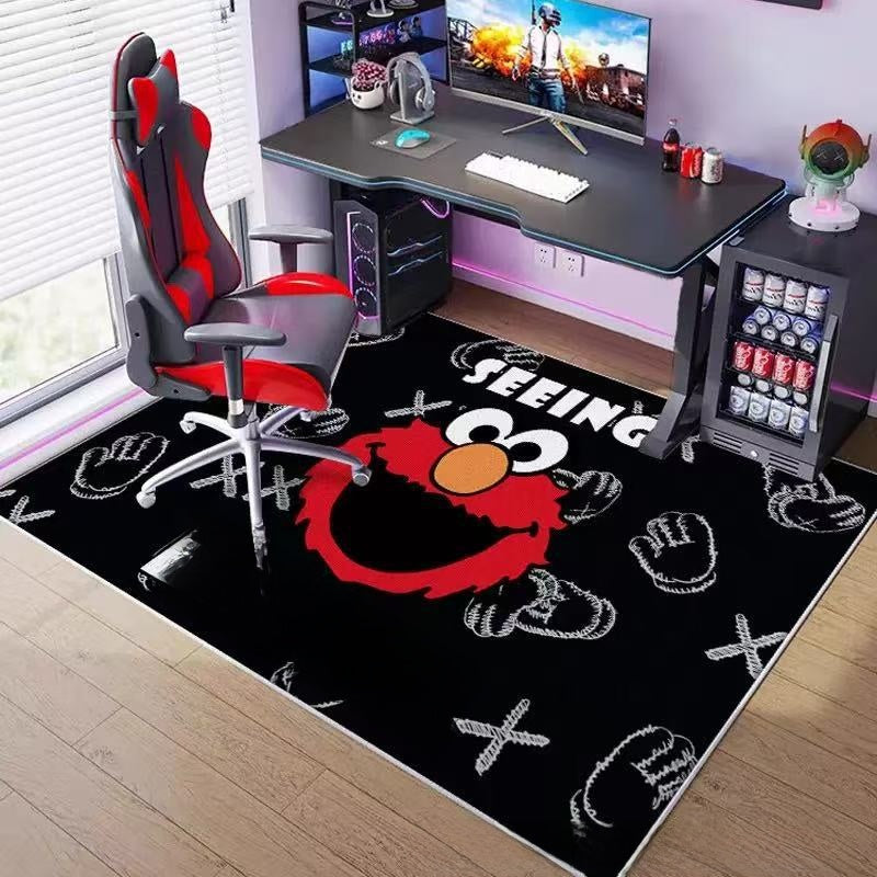 Gaming setup with a black rug featuring a red character, a gaming chair, and a desk with computer equipment.