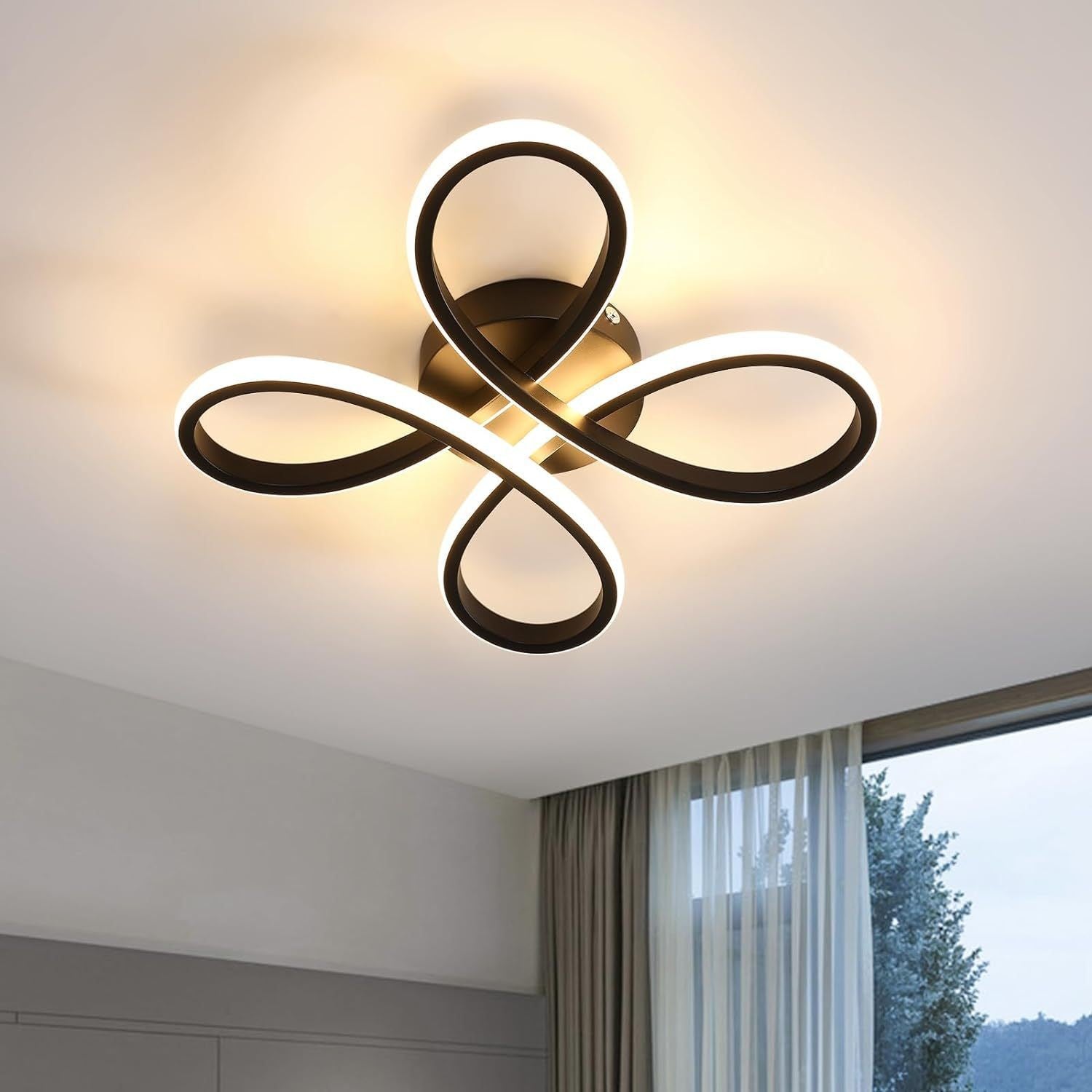 Modern ceiling light fixture with black and white design in a room with a window.