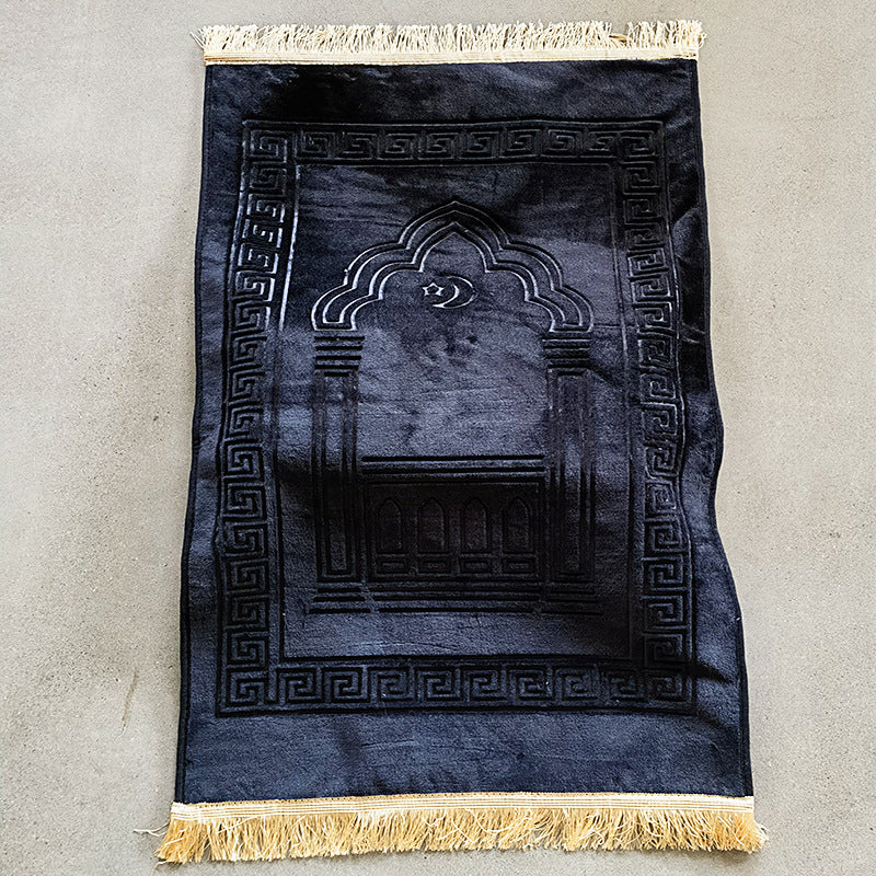 Black prayer rug with gold tassels on a gray background