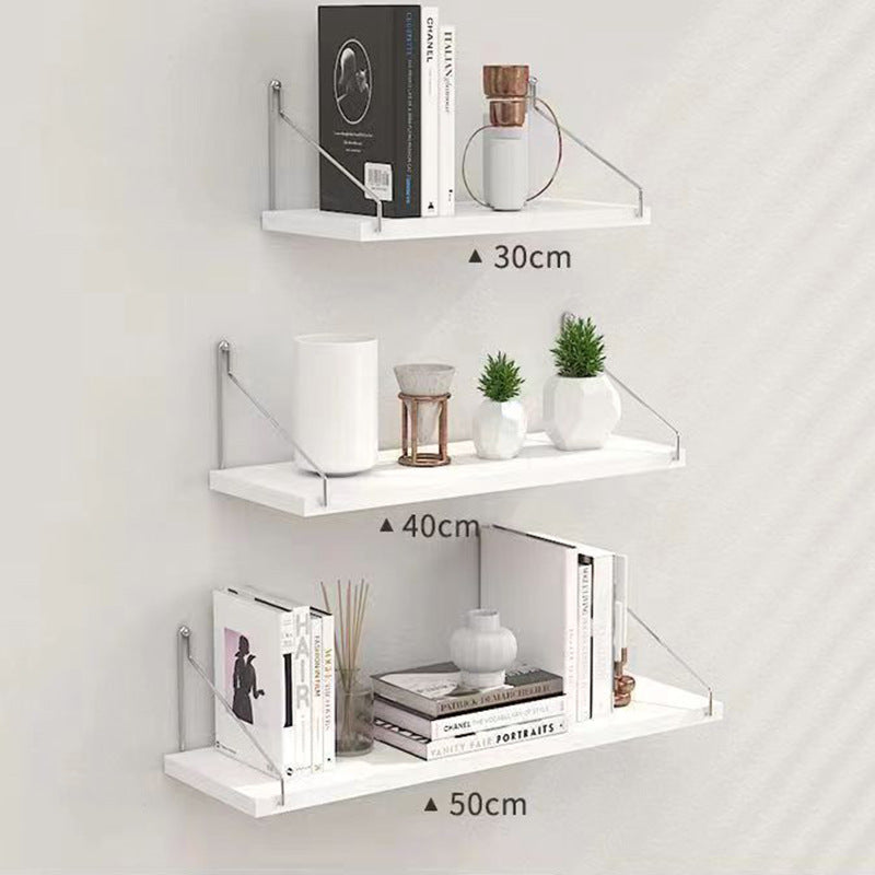 White wall shelves with various decorative items on a light gray background