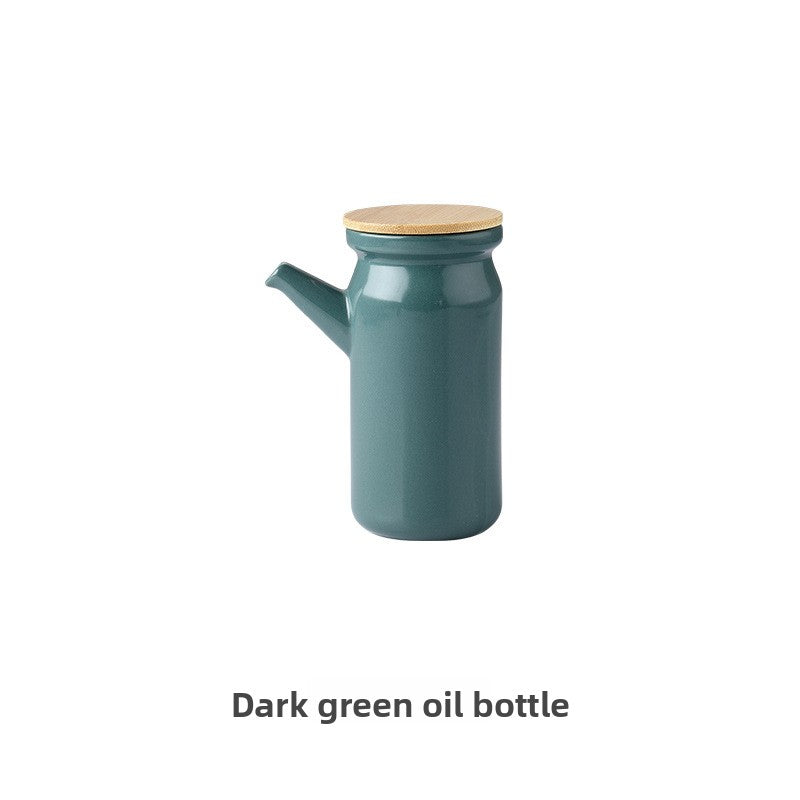 Dark green oil bottle with a wooden cap on a white background