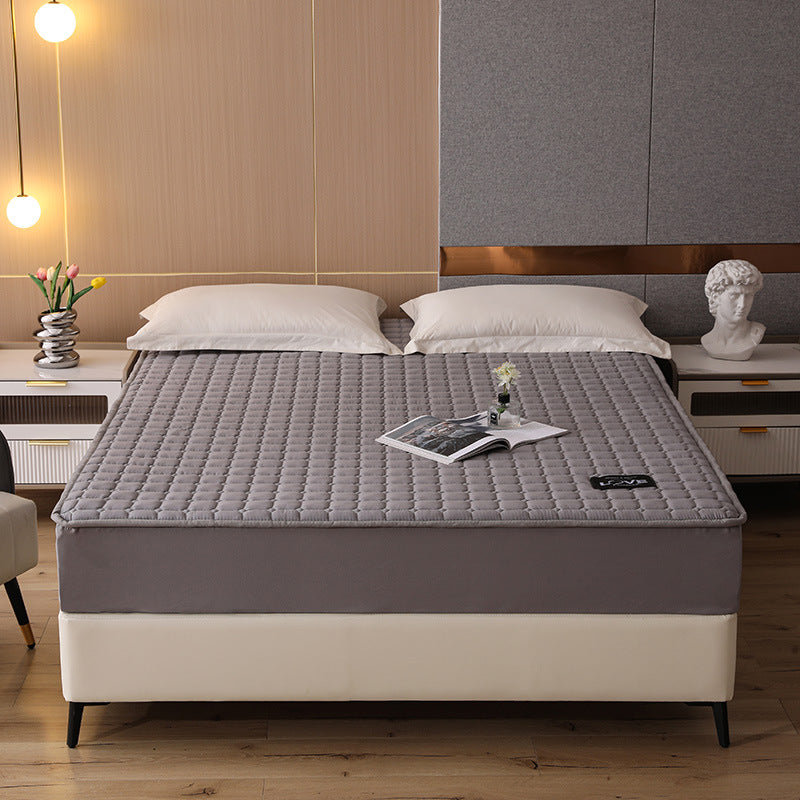 Gray mattress topper on a bed in a bedroom setting with decor elements.
