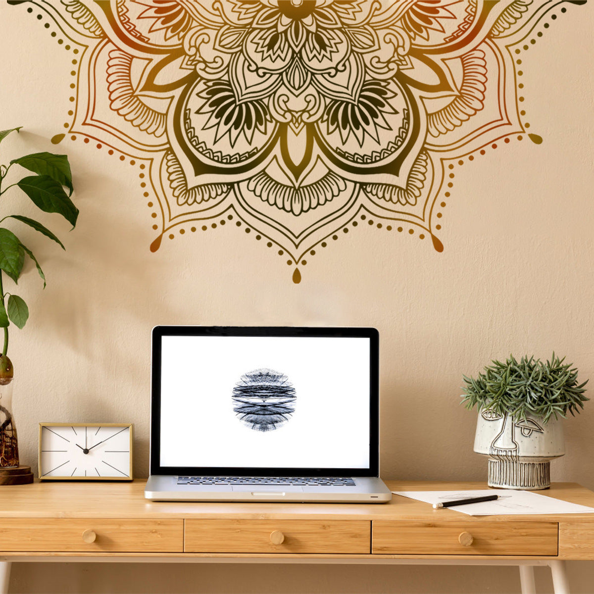 Decorative mandala wall decal on a beige wall with a laptop on a wooden desk.