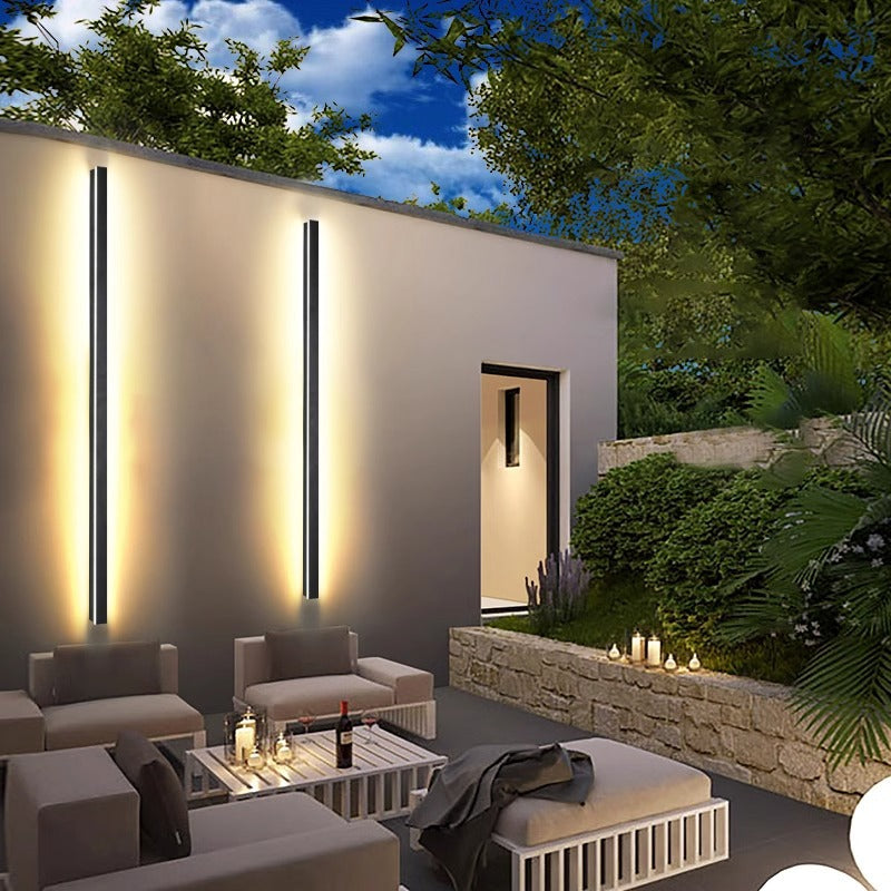 Modern outdoor patio with lighting fixtures, furniture, and candles.