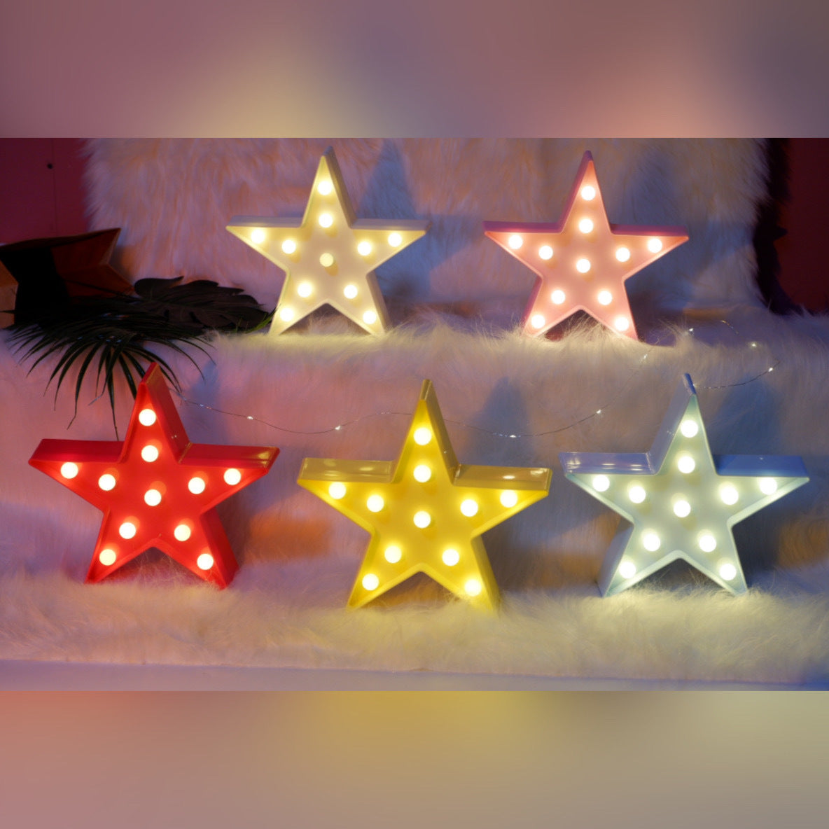 Set of colorful star-shaped lights on a soft surface with a blurred background