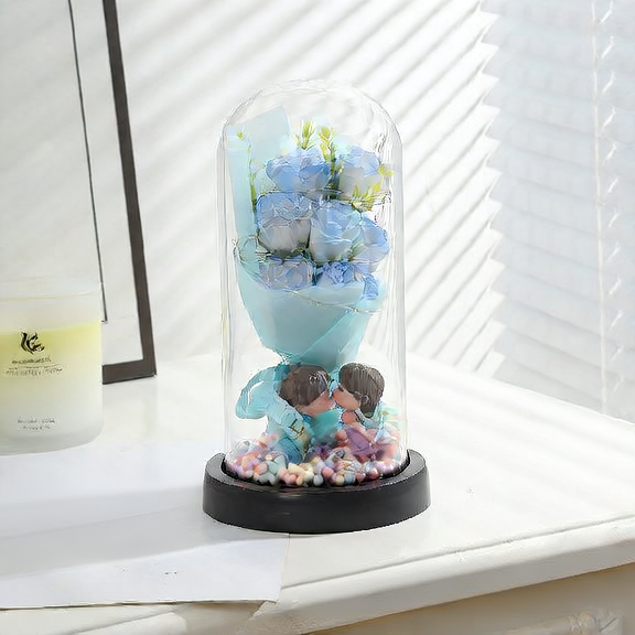 Bouquet of blue roses in a glass dome with two teddy bears on a white surface.