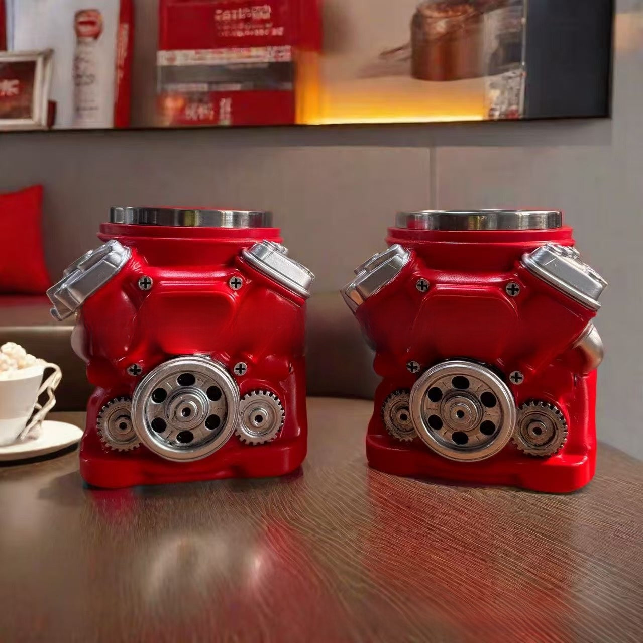 Two red engine-shaped candle holders on a wooden surface with a blurred background.