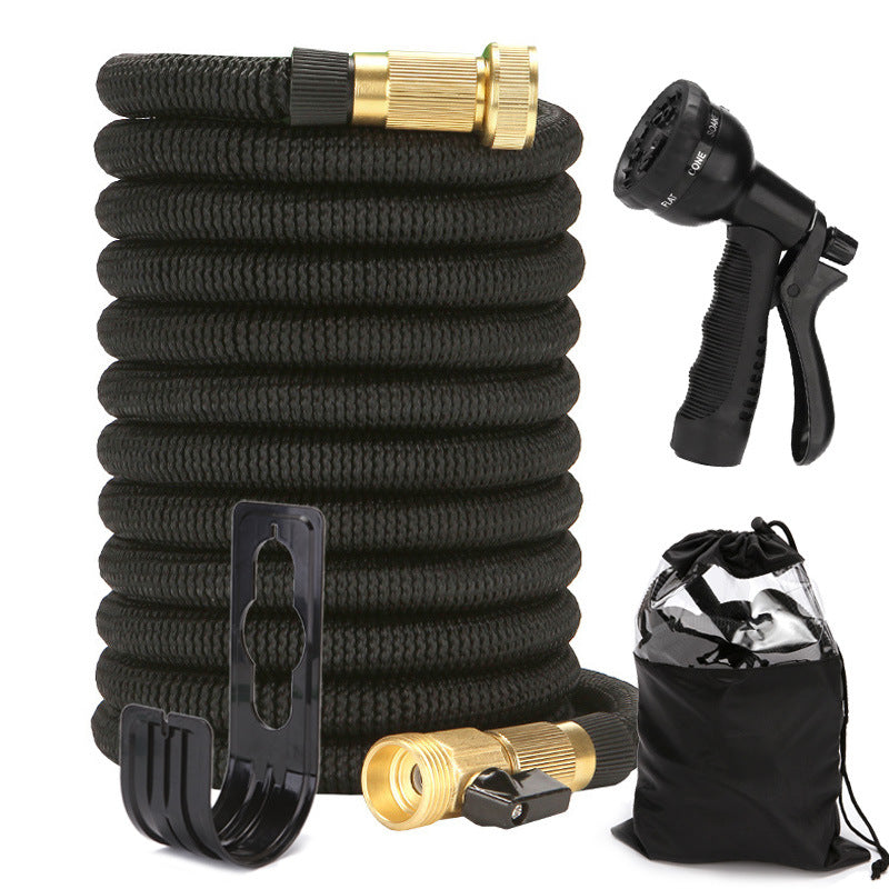Black expandable garden hose with gold connectors, black spray nozzle, and black carrying bag on a white background.