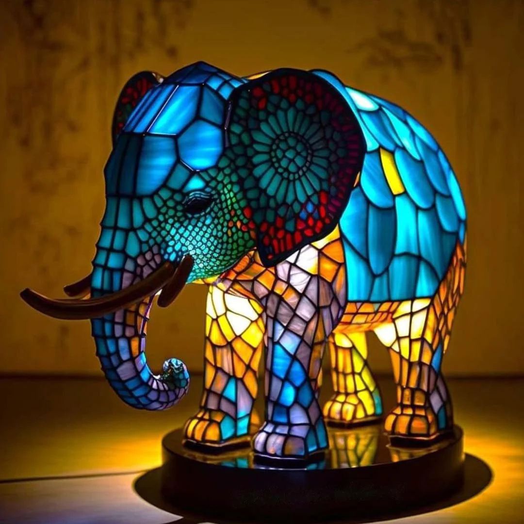 Colorful elephant-shaped lamp with stained glass design on a dark background