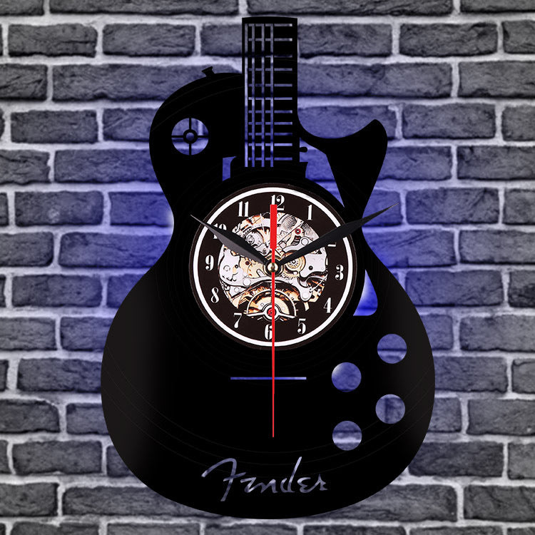 Guitar-shaped wall clock with mechanical design on a brick wall background