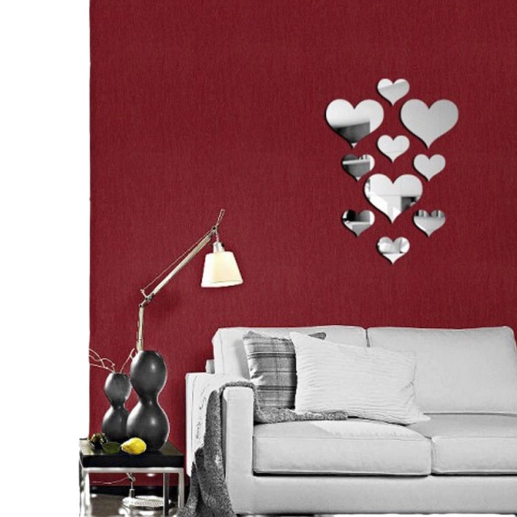 Living room with a red wall, gray sofa, and decorative mirror hearts.