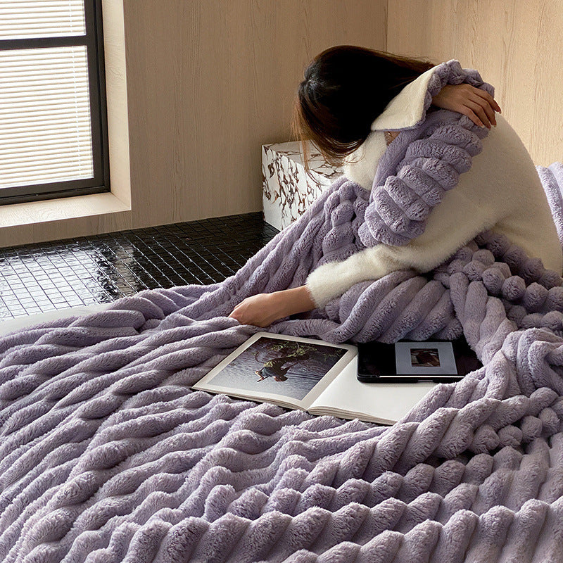 Person wrapped in a fluffy purple blanket in a cozy room.