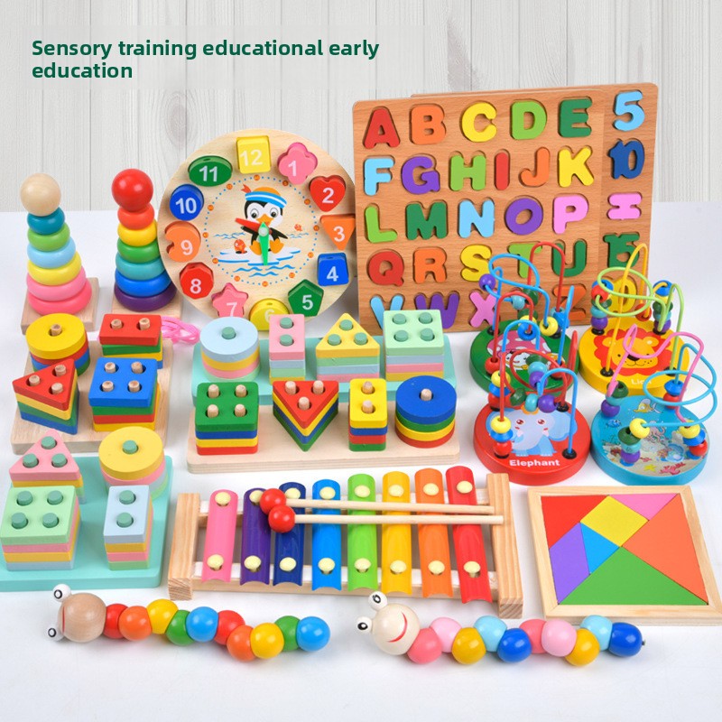 Assorted colorful educational toys on a white surface with a wooden alphabet board.